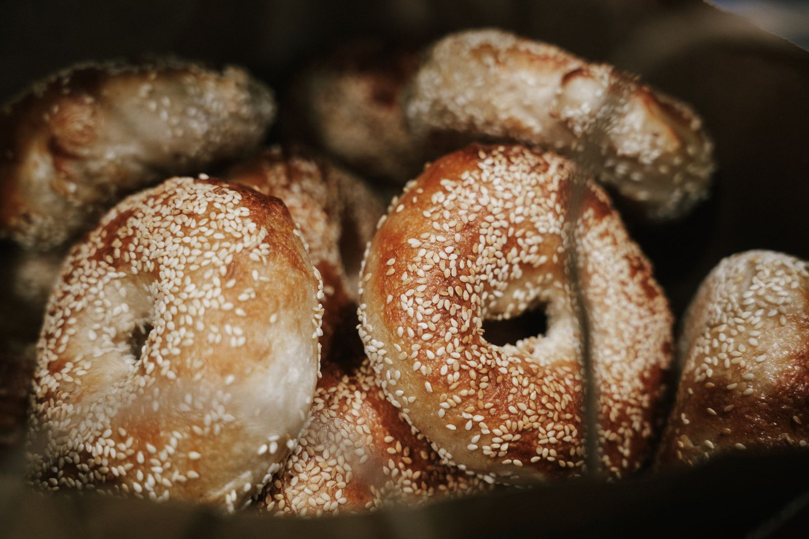 A paper bag full of fresh sesame bagels