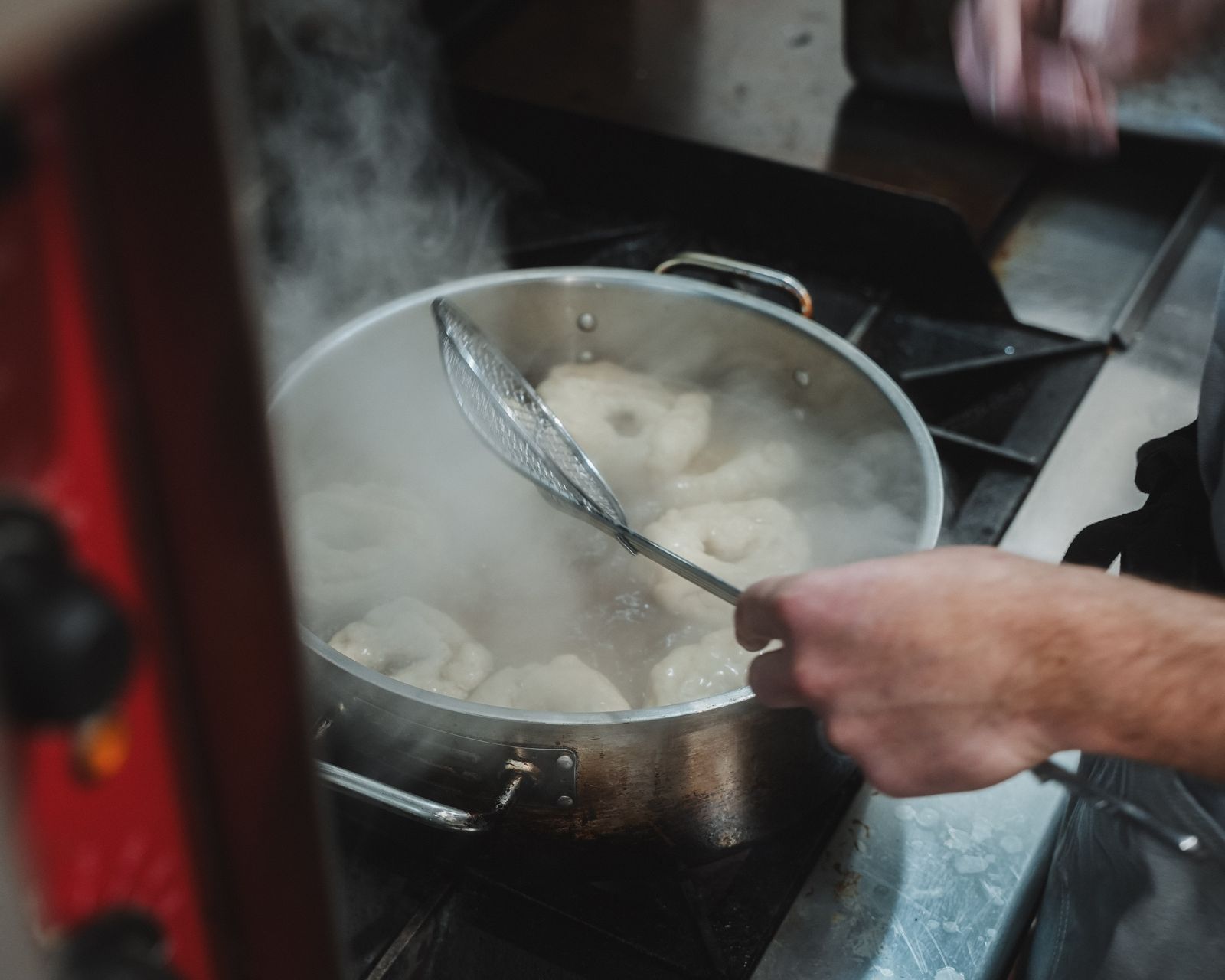 Bagels boiling in a steaming pot, Montreal-style