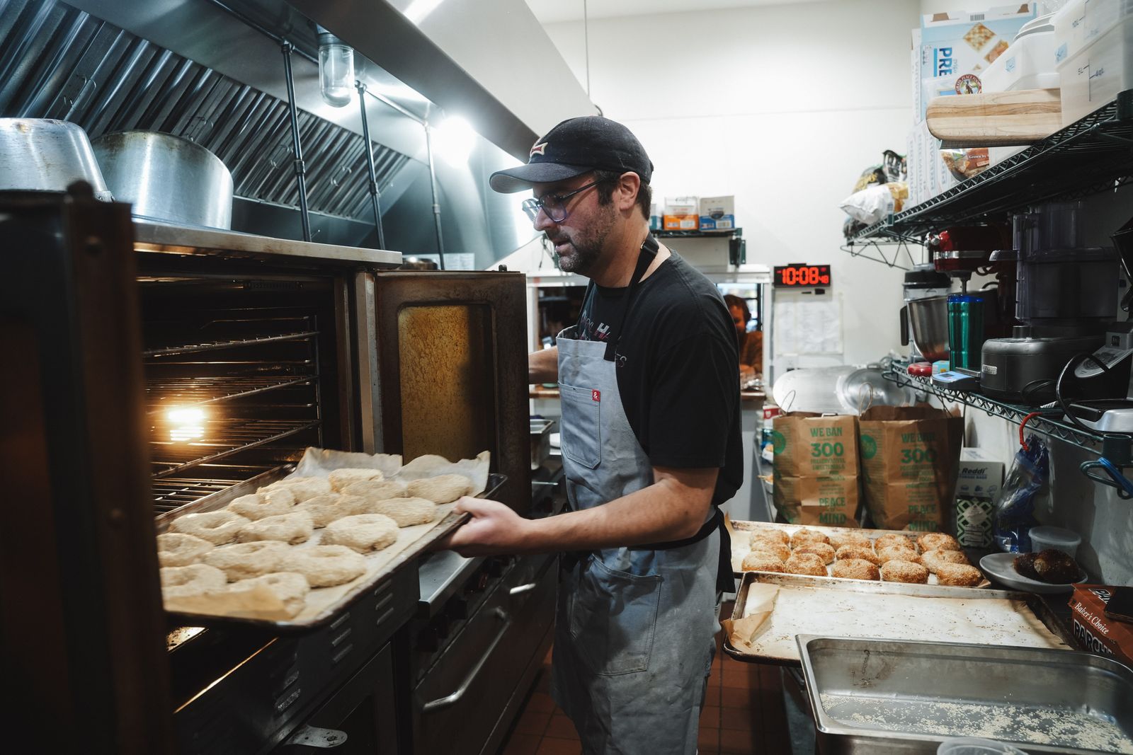 Loading trays of bagels into the oven